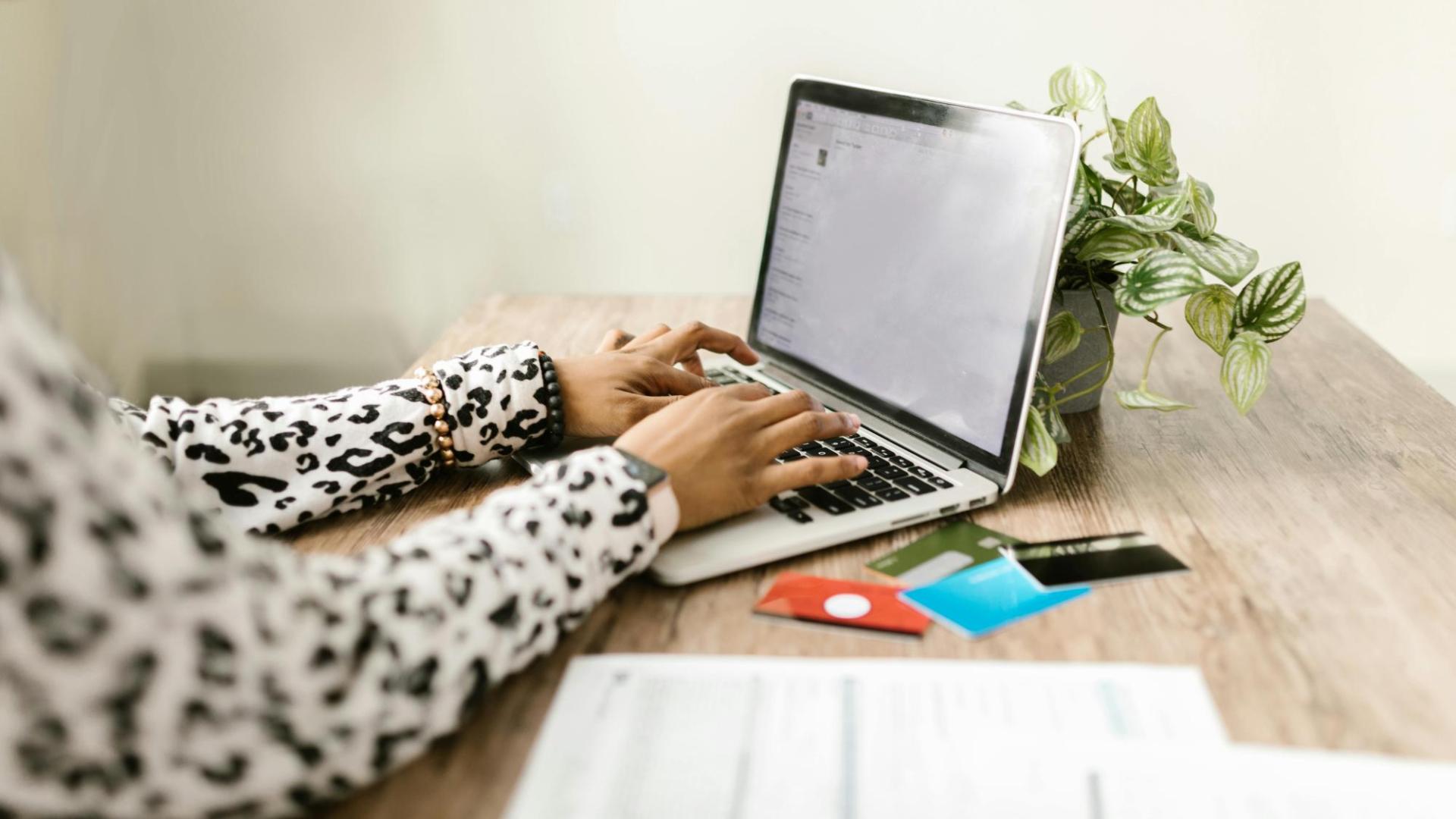 woman on computer with a debit card